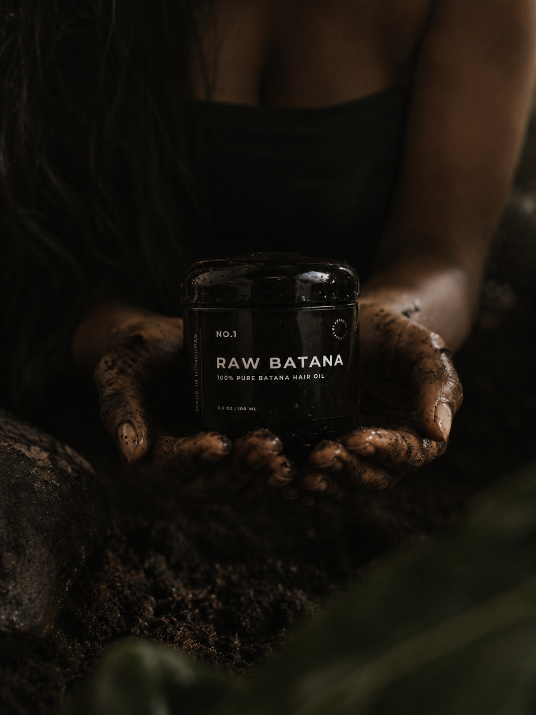 Hands cradling a jar of Raw Batana